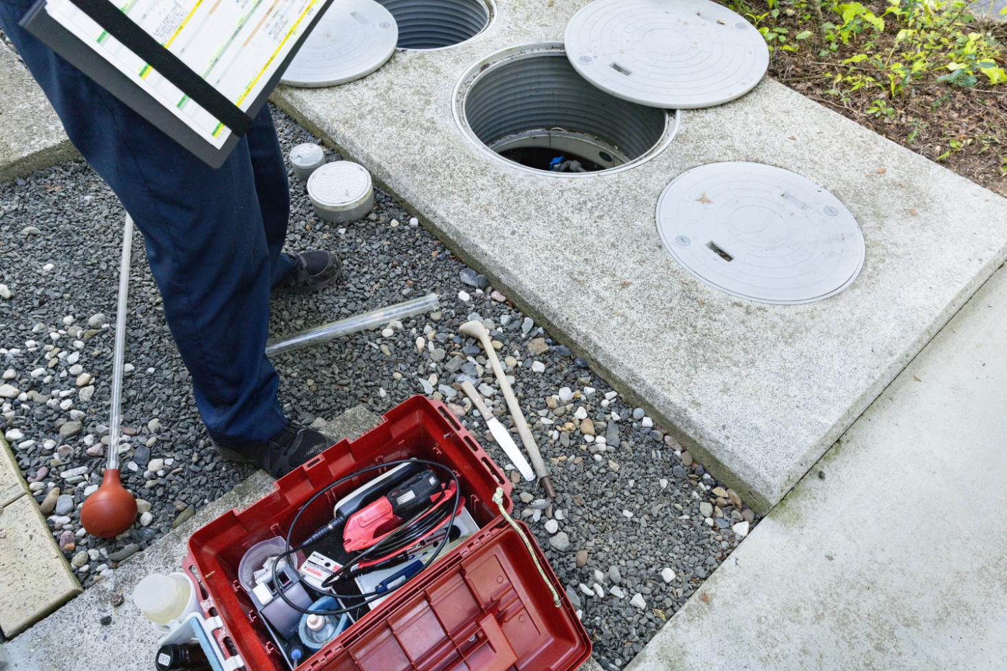 Man installing a pipe in a dirt pit.